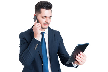 Attractive young businessman working using cellphone and digital