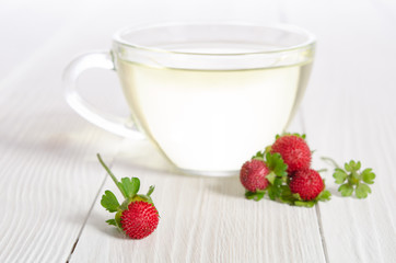 Cup of tea and strawberries on the white wooden table