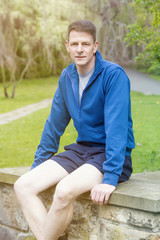 portrait of man in sportswear sitting outdoors