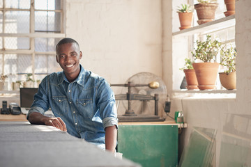 Handsome African designer sitting inside his workshop studio