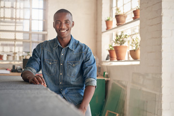 Confident African small business owner sitting inside his studio