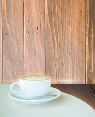 Coffee latte cup on corner of wooden background