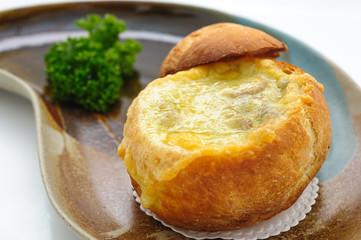 Cheese cream soup served in a loaf studio shot