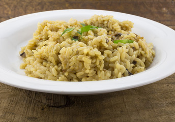 Mushroom risotto close up in white plate on wood