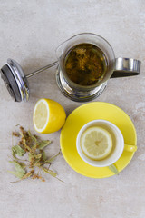 Linden tea in yellow cup. Beige background. Five o'clock, tea time. 