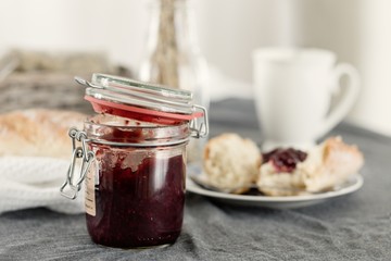 Strawberry marmalade jar with fresh baguette for breakfast