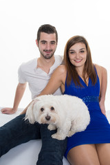 Young and lovely happy couple with their loving white dog