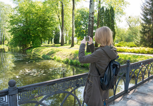 Girl takes pictures landscape and doing selfie on cell phone.