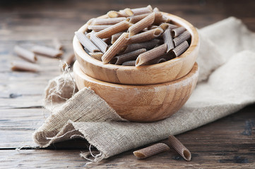 Uncooked buckwheat pasta on the wooden table