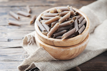 Uncooked italian buckwheat pasta on the wooden table