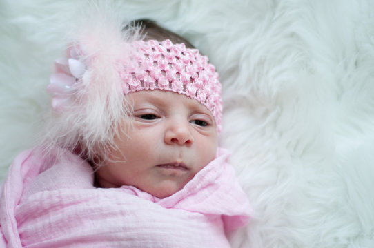 Close up of newborn baby girl in pink