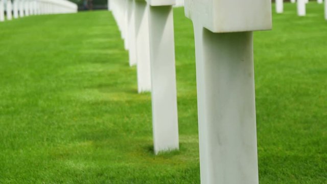 The US flaglet on the bottom of the white cross in Normandy Cemetery  that honors American troops who died in Europe during World War II.