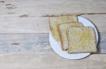 Bread in white dish put on wooden desk.(Selective focus.)