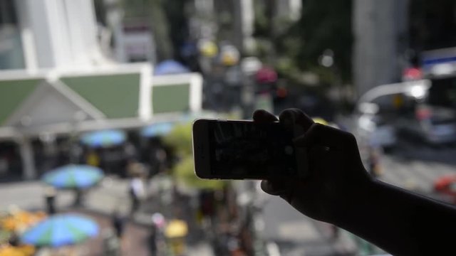 Silhouette of Unknown man taking a photo via smartphone in city of Bangkok,Thailand.