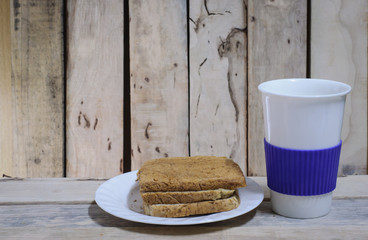 Bread and coffee cup on wood desk background.(Selective focus.)