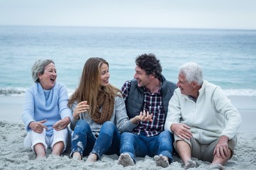 Smiling family sitting at sea shore