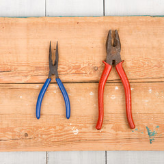 Old pliers on wooden background