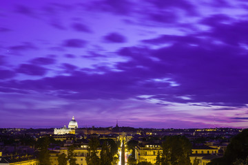 Anxiety overcast sky. Lights of the city at night . Piazza del Popolo Rome Italy. St. Peter's Basilica on the horizon in the distance