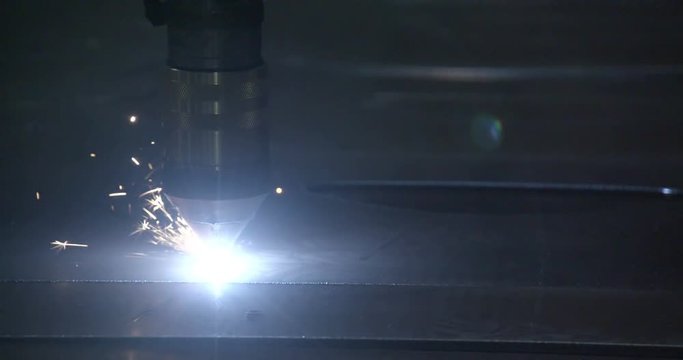 Lights coming from the tip of the machine that creates pattern on the metal sheet that is being processed