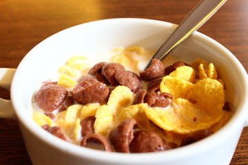 morning meal of cereal and milk in the form of fresh liquid which is above the bowl