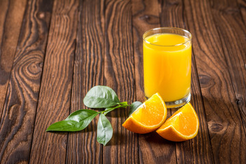 glass of juice and orange slices on a table