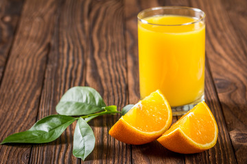 glass of juice and orange slices on a table