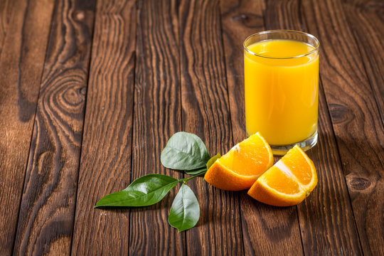 glass of juice and orange slices on a table