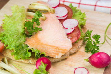 Fresh homemade pita sandwich with hot smoked salmon, letuce and vegetables.