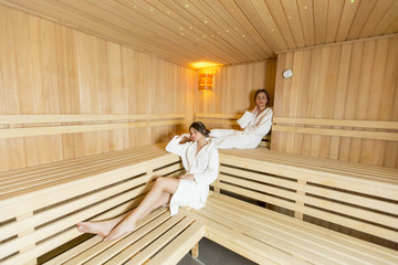 Women relaxing on the bench in the sauna