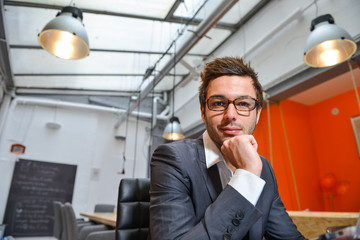 Portrait of smiling Businessman posing  in coworking office