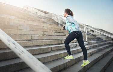 Sporty woman athlete working out running on stairs outdoors.