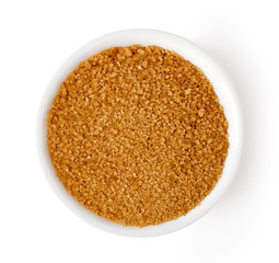Bowl of brown sugar isolated on white, from above