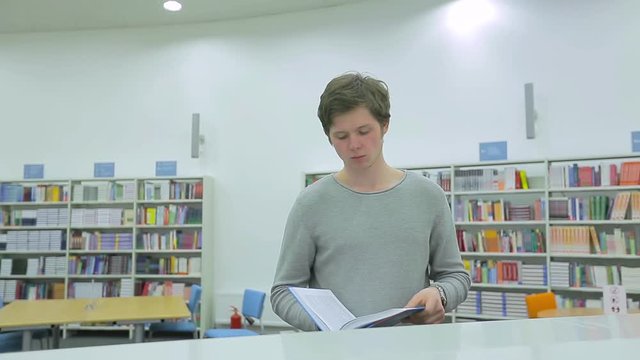 Student Taking Book from Bookshelf in Library