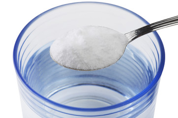 Spoon of baking soda over glass of water