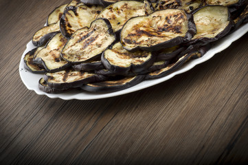 Fototapeta na wymiar Aubergines eggplants and slices grilled on the plate