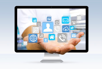 Businessman escaping from computer holding web icons