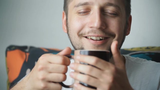 man with pleasure inhaling the smell of coffee. Guy drinks coffee from cup