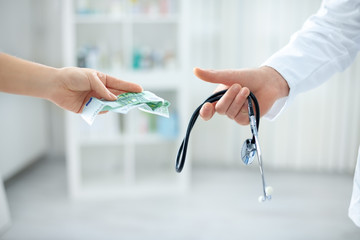 Corrupt doctor taking bribe from patient