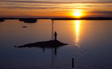 Fototapeta na wymiar sunset at the sea with silhouette lighthouse