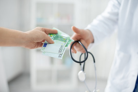 Patient is giving money to a doctor
