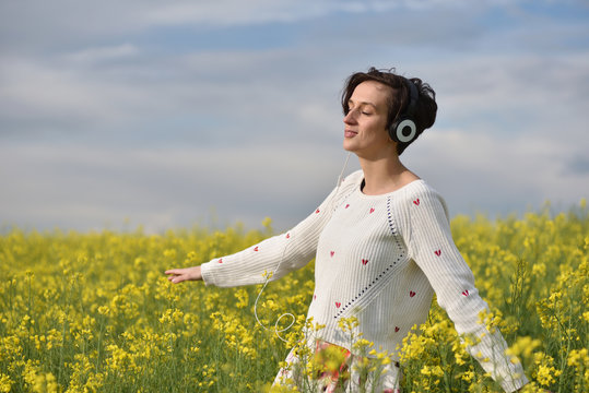 Young, emotional and happy woman listening music in headphones i
