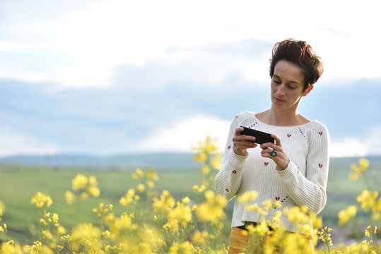 Young woman using her smart phone in the outdoors