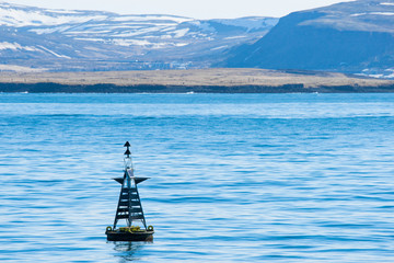 Naklejka premium Buoy silhouette in the blue ocean