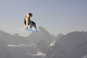 Snowboard rider jumping on mountains. Extreme snowboard freeride sport.