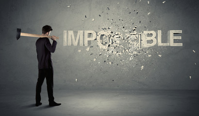 Obraz premium Business man hitting impossible sign with hammer