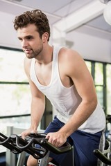 Plakat Man working out on exercise bike at spinning class
