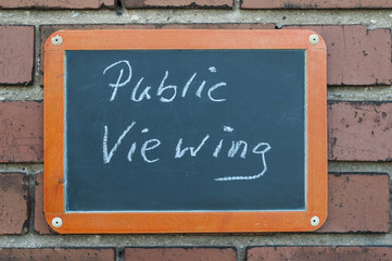 Tafel an einer Ziegelwand mit Text / Tafel an einer Ziegelwand mit Text Public Viewing.