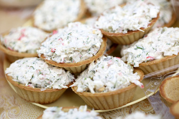 Tartlets with salad on yellow plate