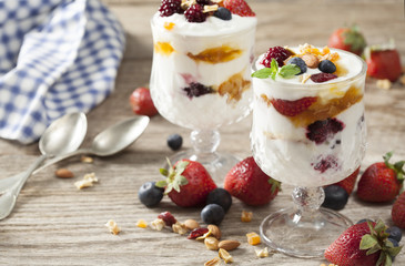 Yogurt with fruits on wooden table