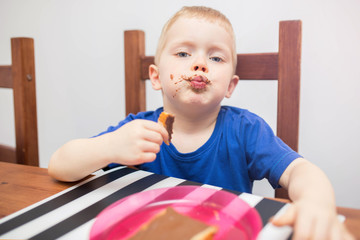 Small boy eating cocoa cream for breakfast